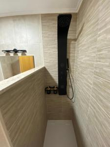 een badkamer met een douche met een zwarte douchekop bij TRES COLUMNAS in Ciudad-Rodrigo