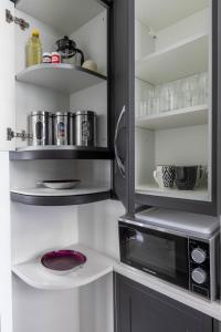 cocina con microondas en blanco y negro en Luxury 1BR Broadstairs: 2 mins walk to the beach en Kent