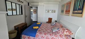a bedroom with a bed with a red and blue bedspread at L'appartement de l'Horizon - Plateau Cailloux in Fleurimont