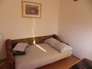 a couch in a room with two pillows on it at Apartments Riva in Pag