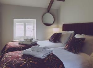 two beds with towels on them in a bedroom at Harbourway in Craster