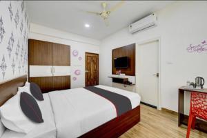 um quarto com uma cama, uma secretária e uma televisão em Prince residency Venue em Bangalore