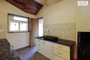 a kitchen with a counter top and a window at StayVista at Riverfront Cottage in Jabalpur