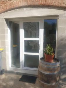 a sliding glass door with a plant in a barrel at spacieux T2 confortable in Saint-Vallier