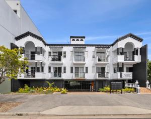 un edificio blanco con balcones en una calle en Villa Vaucluse Apartments, en Cairns