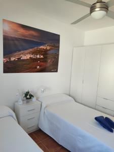 Un dormitorio con dos camas y un cuadro en la pared. en Apartamento El Flamenco Azul Cabo de Gata, en Almería 28 fotos más