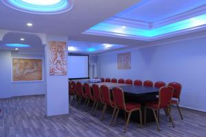 a conference room with a table and red chairs at The Marine Hotel in Trabzon
