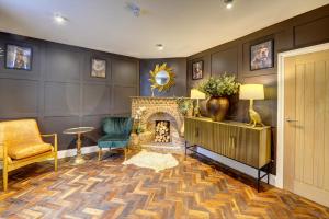 a living room with a fireplace and two chairs at The Bridge House Henley in Henley in Arden