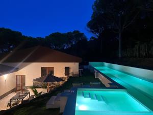 uma piscina em frente a uma casa à noite em Luxury private Villa 25m Pool, Gym, 200m to Beach em Cañet de Mar