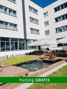 un edificio con una fuente frente a un edificio en CKS Warszawa (Centrum Konferencyjno-Szkoleniowe CS Natura Tour) en Varsovia