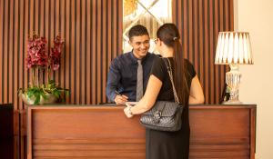 a man and a woman standing at a desk at Fourteen Hotel Ain Sebaa in Casablanca