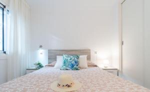 1 dormitorio con 1 cama con sombrero en Apartment Meda Chica, en Roses