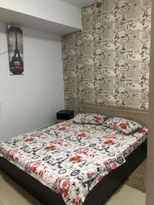 a bedroom with a bed with a floral comforter on it at Neversea Black Sea in Constanţa