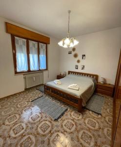 um quarto com uma cama e um lustre em Le ballerine em Crocetta