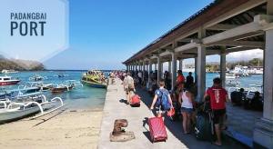 a group of people standing at a dock with luggage at Gilibooking tickets in Padangbai