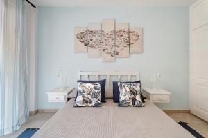ein Schlafzimmer mit einem Bett mit zwei Tischen und zwei Gemälden an der Wand in der Unterkunft Sol y Mar in Puerto de Santiago + 15 Fotos