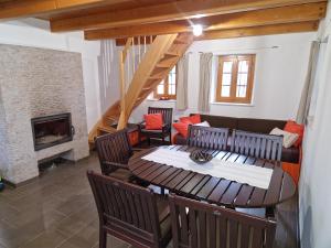 sala de estar con mesa, sillas y chimenea en Sweet Country House, en Markovci