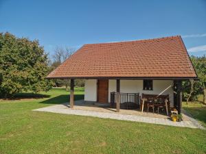 a small house with a roof with a table at Sweet Country House in Markovci