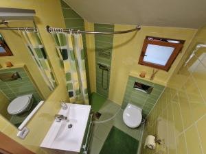 bagno con 2 servizi igienici, lavandino e doccia di Sweet Country House a Markovci