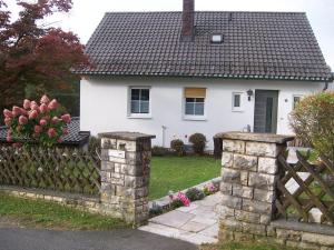 a fence in front of a white house at Ferienoase im Zottbachtal in Pleystein