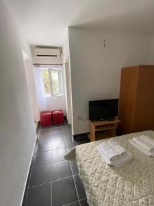 ein Schlafzimmer mit einem Bett und einem TV in einem Zimmer in der Unterkunft Vila Dvorski in Baška Voda