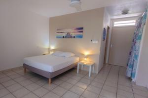 a bedroom with a bed and a table and a window at Studio Tamarin lagon de trou d'eau in La Saline les Bains