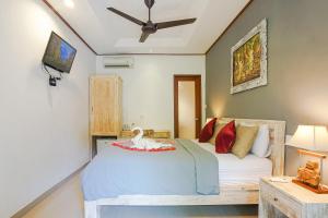 a bedroom with a bed with a swan on it at Wayan Homestay Sanur in Sanur