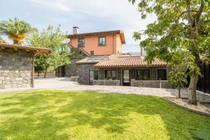 uma casa com um relvado em frente em Villa Oliva Ecofriendly em Aci Catena