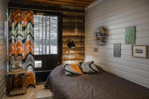 a bedroom with a bed in a room with a window at Villa Uuttu in Kuusamo