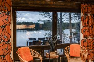 a screened in porch with chairs and a view of a lake at Villa Uuttu in Kuusamo