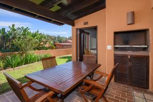 a wooden table and chairs on a patio at San Lameer Villa 3314 - 2 Bedroom Superior - 4 pax - San Lameer Rental Agency in Southbroom