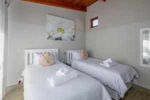 two beds in a room with white sheets and towels at San Lameer Villa 3314 - 2 Bedroom Superior - 4 pax - San Lameer Rental Agency in Southbroom +20 photos