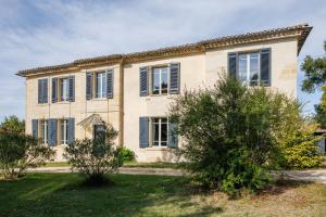 ein großes Haus mit blauen Fensterläden in der Unterkunft La Papautiere in Carignan