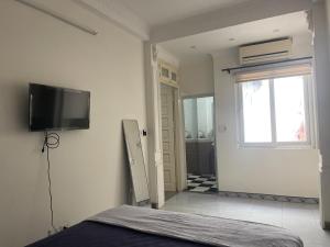 Sword lake hostel في هانوي: غرفة نوم بسرير وتلفزيون على الحائط