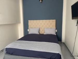 a bedroom with a large bed with a blue wall at Sword lake hostel in Hanoi