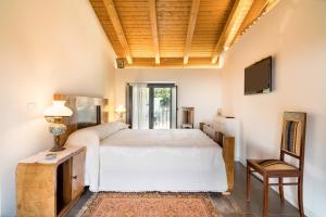 um quarto com uma cama branca e uma televisão em Villa Oliva Ecofriendly em Aci Catena