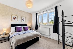 Un dormitorio con una cama grande y una ventana en Stunning 4 Bed House - Sleeps 12, en Cheltenham