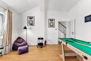 a room with a pool table and a chair at Stunning 4 Bed House - Sleeps 12 in Cheltenham