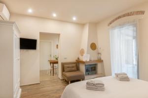 een slaapkamer met een bed en een stoel en een open haard bij Il Piccolo Borgo for 7 guests in Certaldo