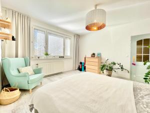 a bedroom with a bed and a chair and windows at Family-Friendly Home in Bratislava in Bratislava