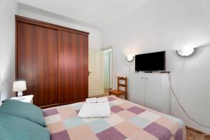 um quarto com uma cama e uma televisão de ecrã plano em Casa Rural Paula Maretas Beach em Santa Cruz de Tenerife