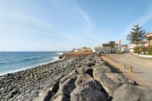 uma praia rochosa com edifícios e o oceano em Casa Rural Paula Maretas Beach em Santa Cruz de Tenerife
