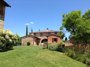 a large stone house with a grassy yard at Casa Cernano in Castelnuovo Berardenga