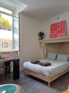 Un dormitorio con una cama con un escritorio y una ventana. en le one, en Agen 4 fotos más