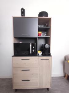 Un centro de entretenimiento de madera con microondas y televisor. en le one, en Agen