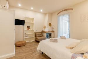 a white bedroom with a bed and a chair at Il Piccolo Borgo in Certaldo +24 photos