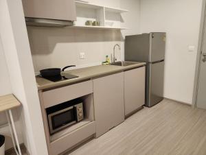 a small kitchen with a sink and a refrigerator at Aspire Ratchada精品公寓 in Bangkok