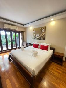 a bedroom with a large bed with red pillows at Yotaka Boutique Hotel Bangkok in Bangkok
