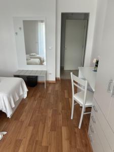 1 dormitorio con cama, mesa y espejo en BnB Nuova Vita, en Paola