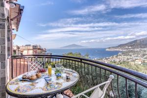 a table on a balcony with a view of the ocean at VILLA CARUSO PRIVATE HEATED POOL & SEA VIEW in Sorrento